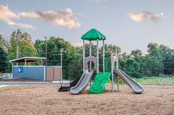 A playground with two slides and a swing set at anthem luxury rentals in huntsville, al